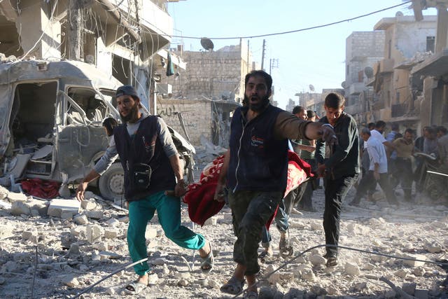 Syrian volunteers carry an injured person on a stretcher following suspected Syrian government forces air strikes on the rebel held neighbourhood of Heluk in Aleppo