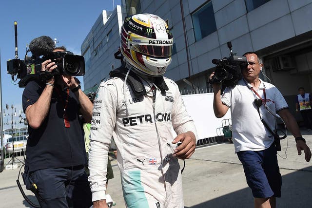 Lewis Hamilton makes his way away from the cameras after suffering defeat