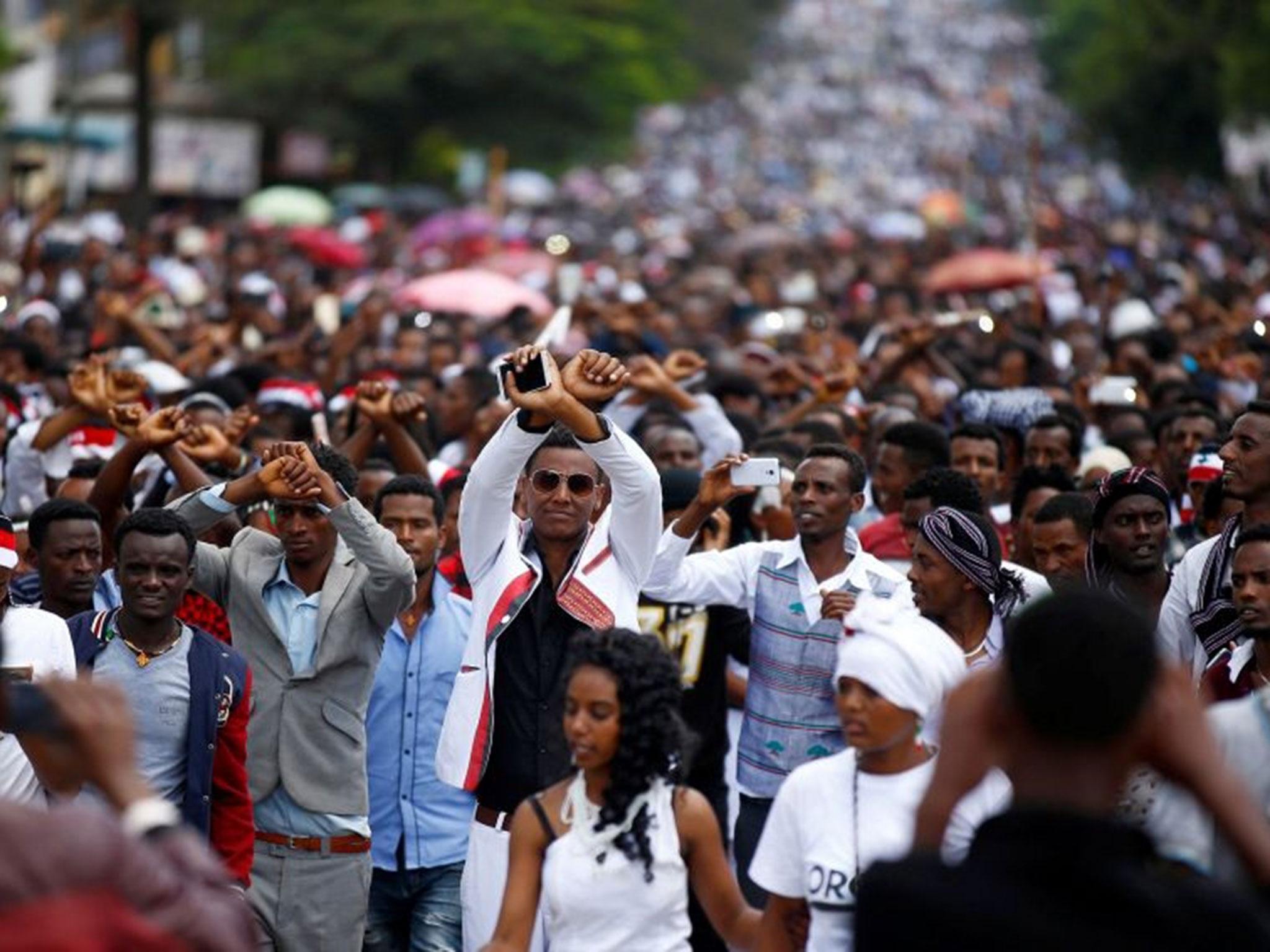 File: Demonstrators show an Oromo protest gesture sign during Irreecha, a thanks giving festival in Bishoftu, Ethiopia