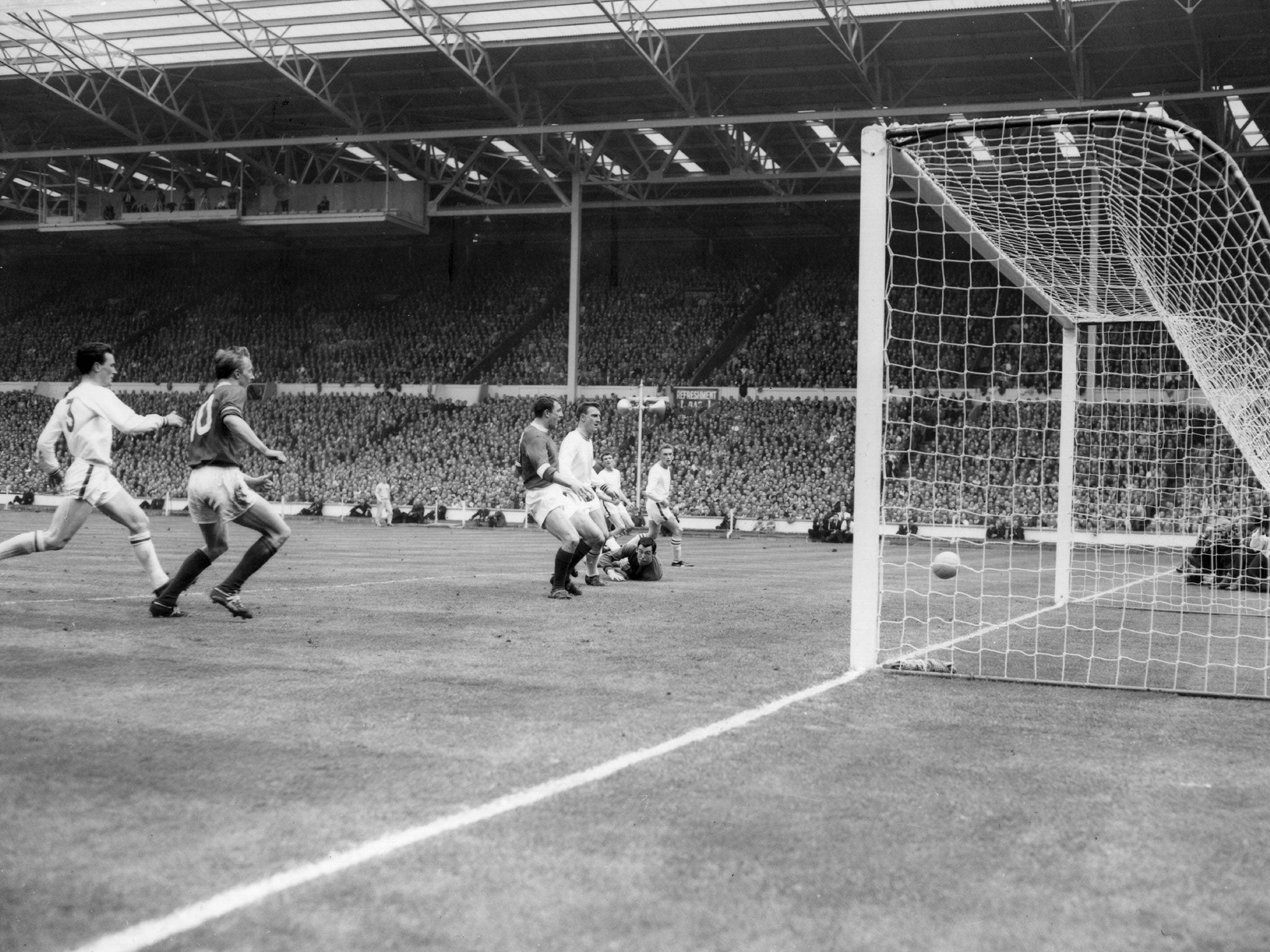 Leicester City goalkeeper Gordon Banks lies flat on the ground as he watches David Herd (left) score Manchester United's second goal, during the FA Cup Final at Wembley Stadium, May 1963. United went on to win 3-1.