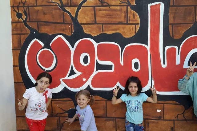 Children in front of a mural at an east Aleppo school