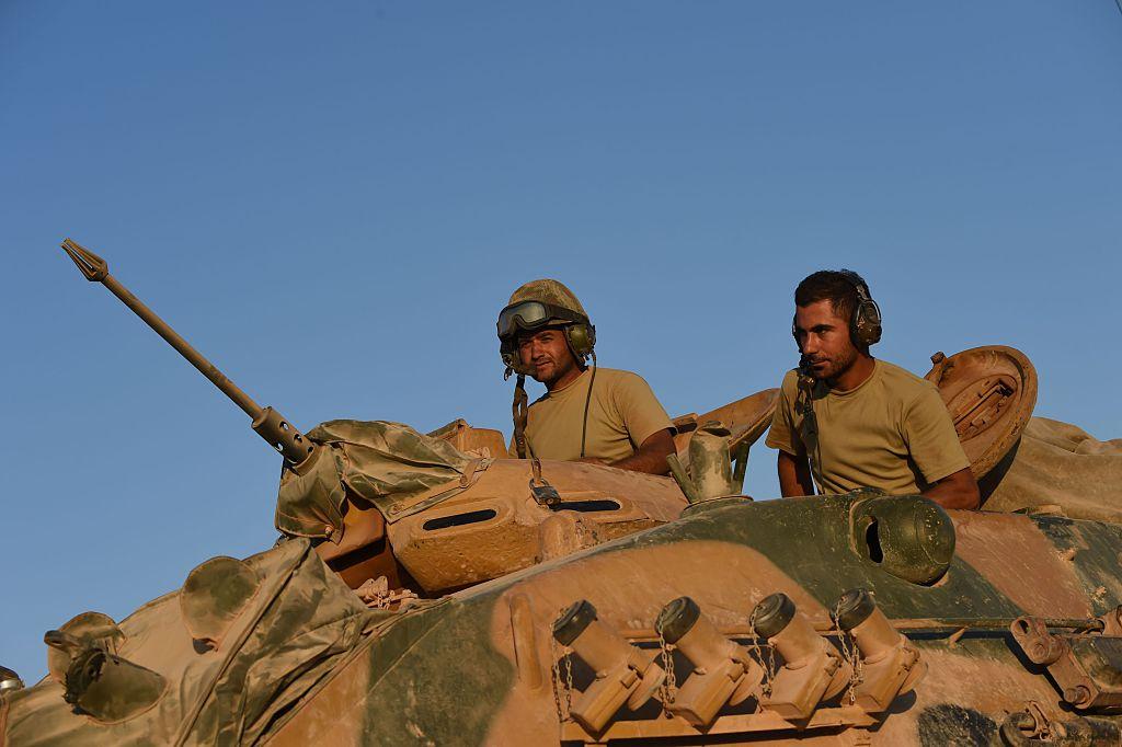 Turkish soldiers stand in a Turkish army tank driving back to Turkey from the Syrian-Turkish border town of Jarabulus on September 2, 2016