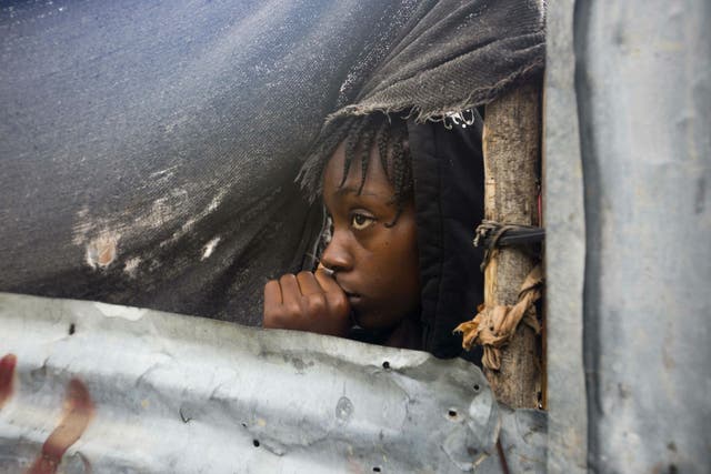 A girl watches as the authorities arrive to evacuate people from her house in Tabarre, Haiti