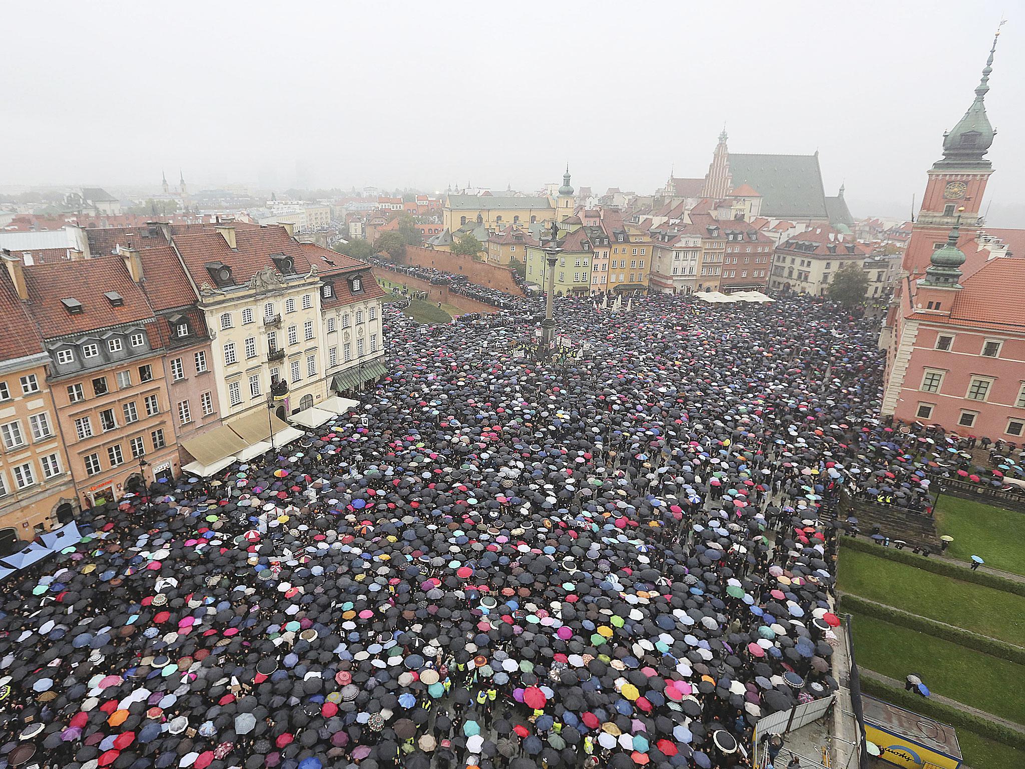 Protesters raise umbrellas as they strike in Zamkowy square in Warsaw, Poland AP