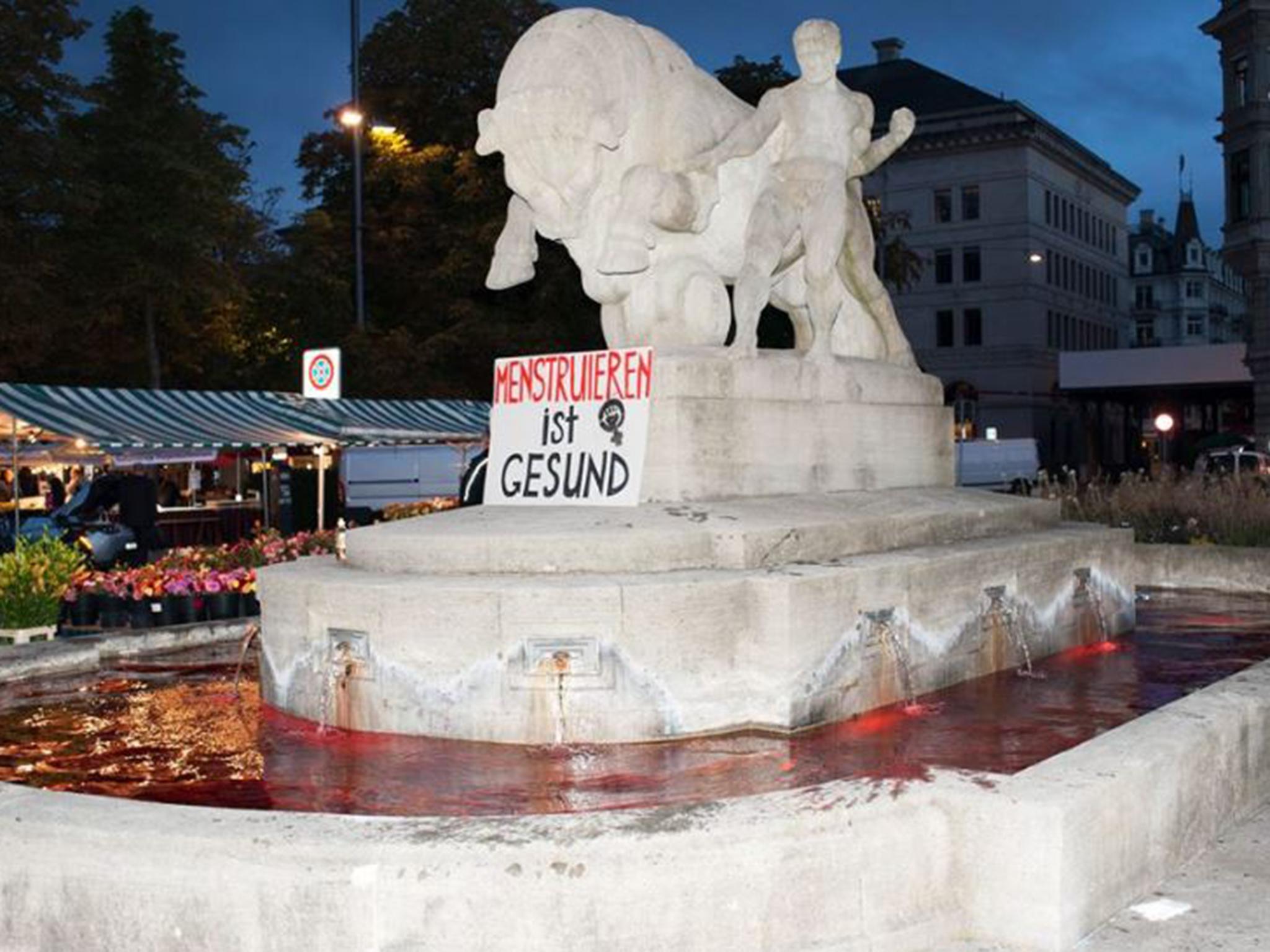 The fountains were dyed with food colouring shortly before dawn. The sign reads "Menstruation is healthy"