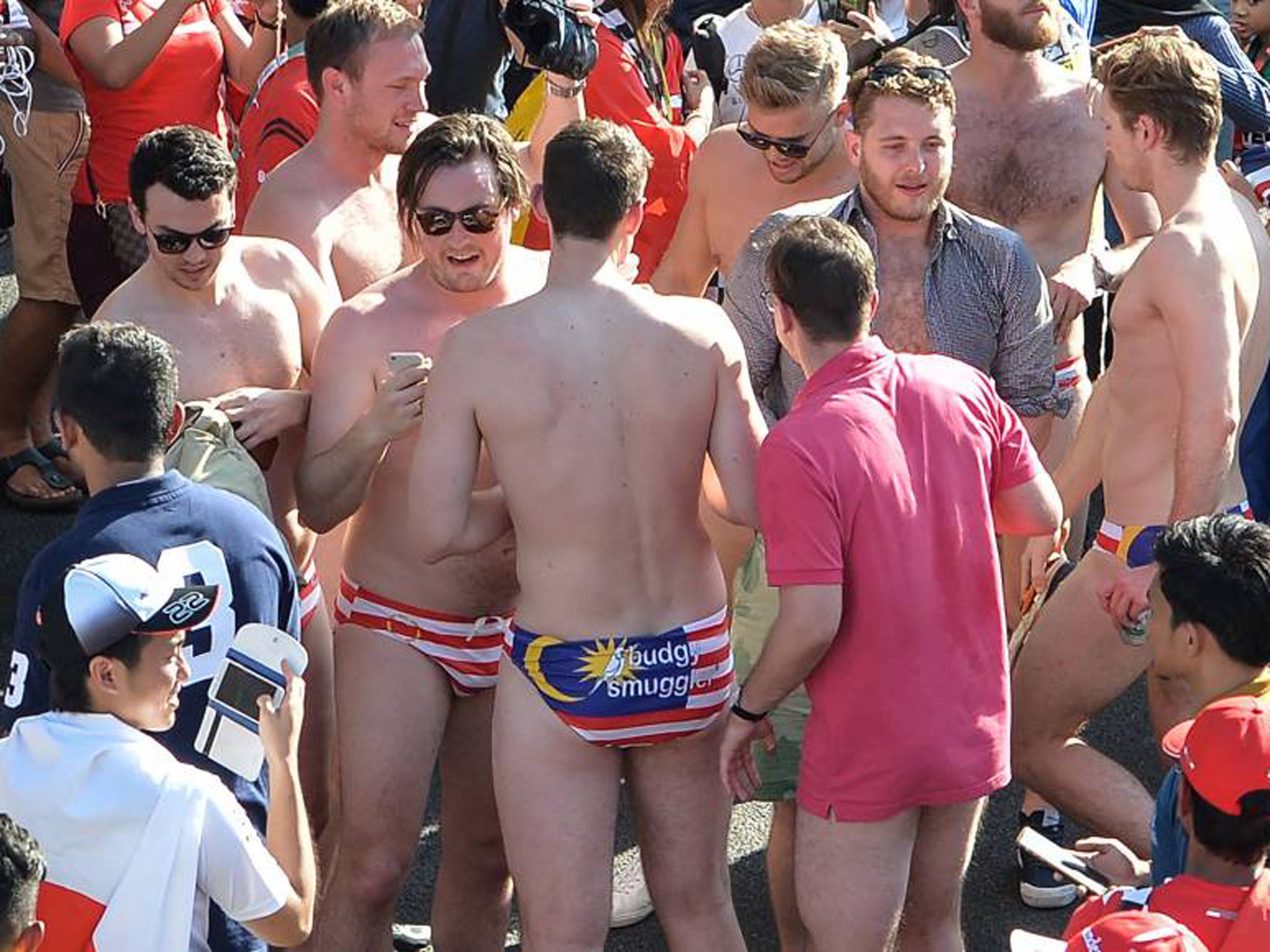 Australian spectators wearing swimwear bearing the Malaysian flag party during the Malaysian Grand Prix