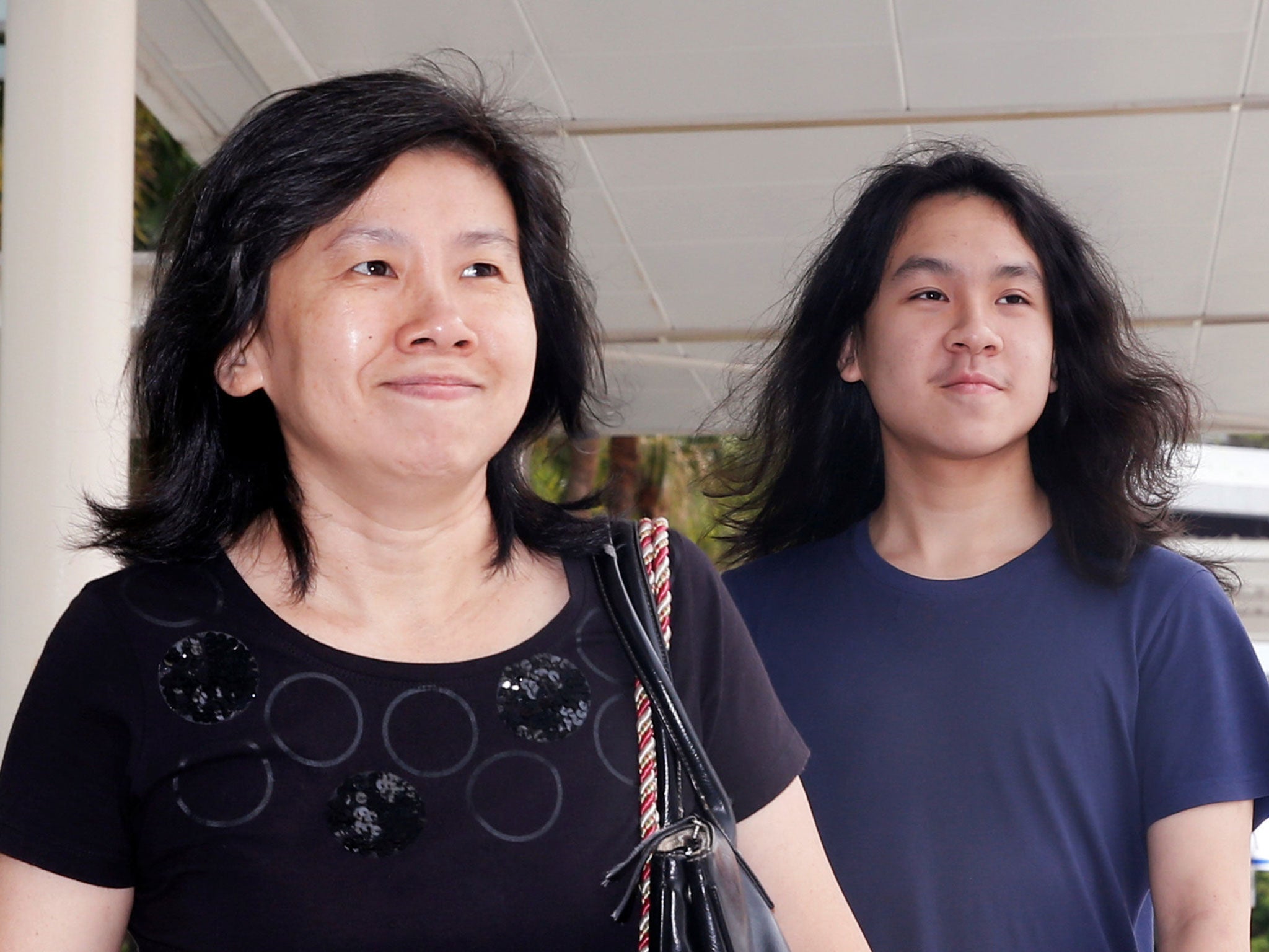 Amos Yee arrives with his mother at the State Courts in Singapore on 28 September