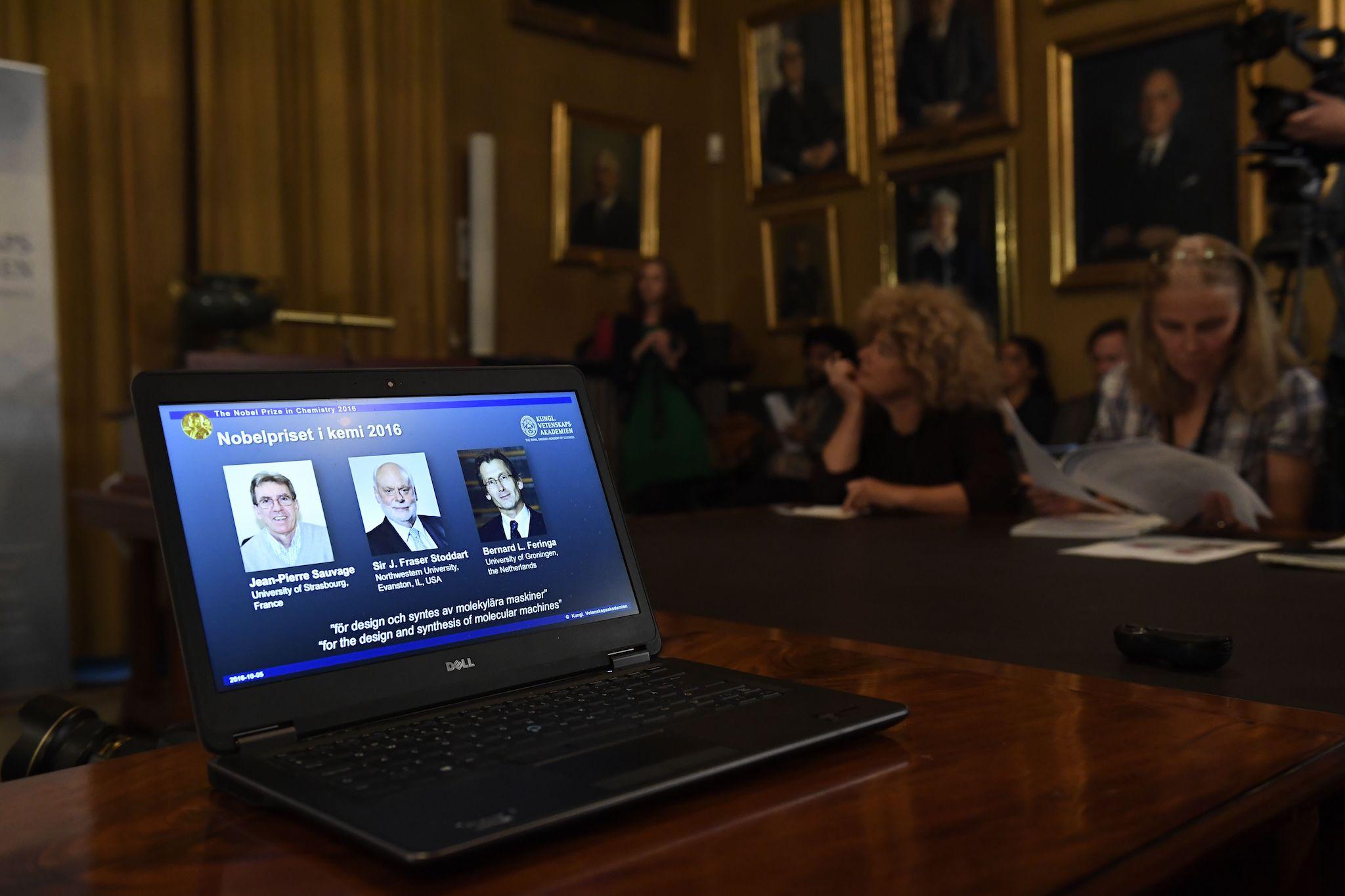 Sir J Fraser Stoddart (centre) appears on a laptop screen as he, Jean-Pierre Sauvage and Bernard L Feringa are proclaimed the winners of the Nobel Prize for Chemistry