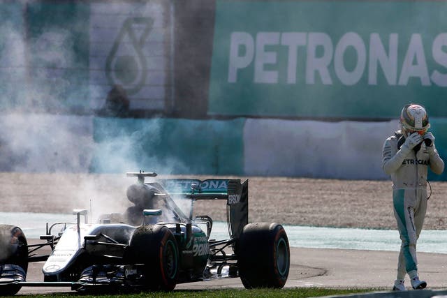 Lewis Hamilton walks away dejectedly after his Mercedes blew its engine 15 laps from the end of the race