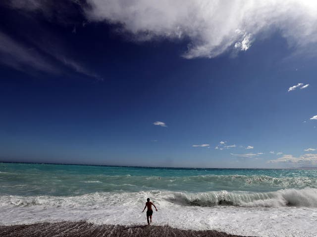 A man runs in front of the waves at the beach on the French Riviera city of Nice