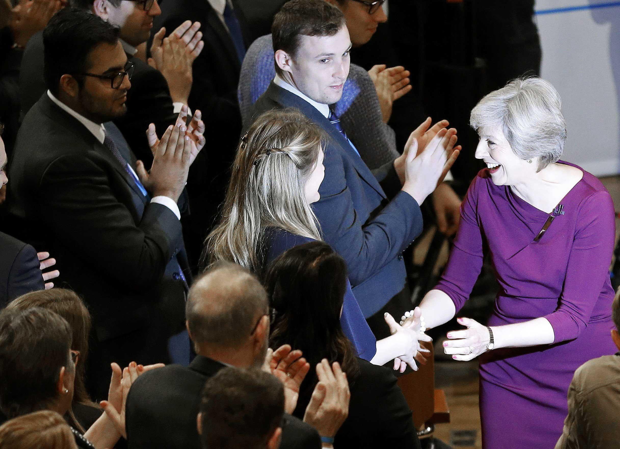 Britain's Prime Minister Theresa May shakes hands with delegates as she leaves the stage after giving her speech on the final day of the annual Conservative Party Conference in Birmingham