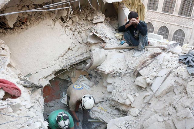 Syrian civil defence volunteers, known as the White Helmets, search for victims amid the rubble of destroyed buildings following a government forces air strike on the rebel-held neighbourhood of Bustan al-Basha in the northern city of Aleppo