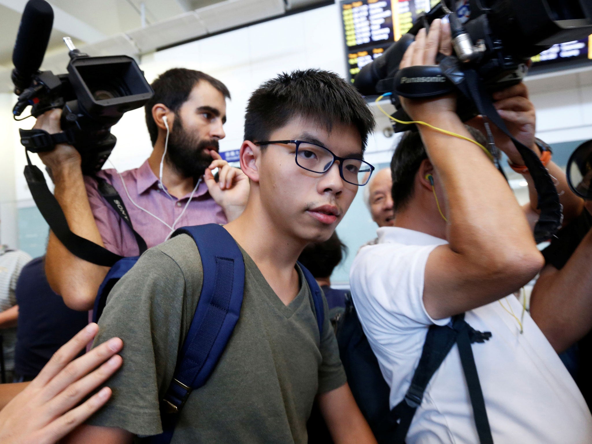 Pro-democracy activist Joshua Wong is surrounded by journalists upon his arrival at Hong Kong Airport in Hong Kong