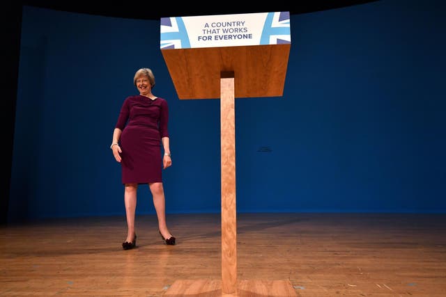 Theresa May reacts after delivering a keynote address on the final day of the annual Conservative Party conference