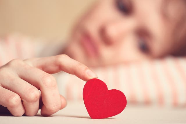 <p>La muchacha triste sostiene el símbolo del corazón junto a su dedo y lo mira. Concepto de amor y relaciones.</p>