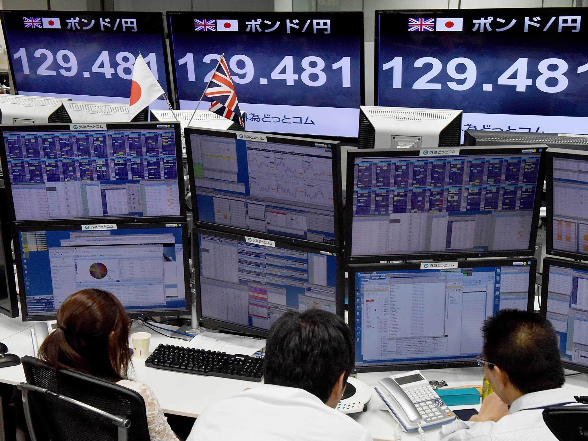 Traders check computer screens showing the Japanese yen rate against the British pound at a brokerage in Tokyo.The pound suffered a "flash crash" in Asia on a computer-generated sell-off in the beleaguered currency.