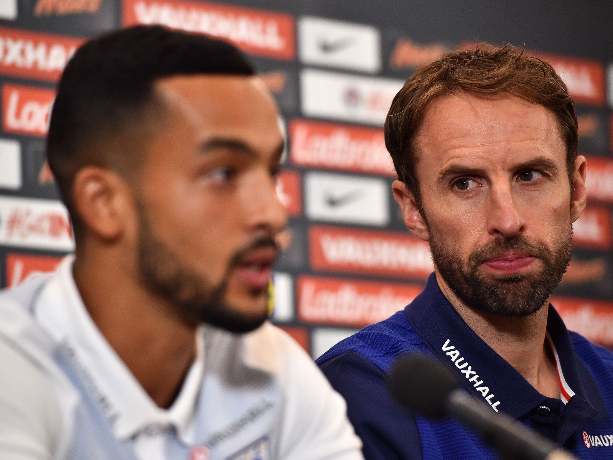 Gareth Southgate looks on as Theo Walcott speaks to the press on Friday