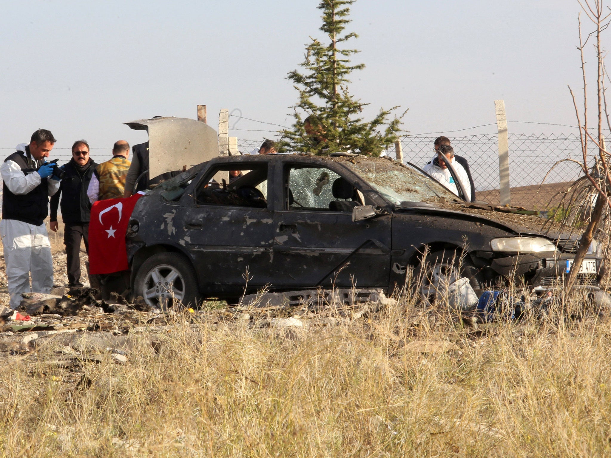 Police forensic experts examine a car after a blast detonated by two militants, in the countryside of Haymana near Ankara, Turkey, October 8, 2016.