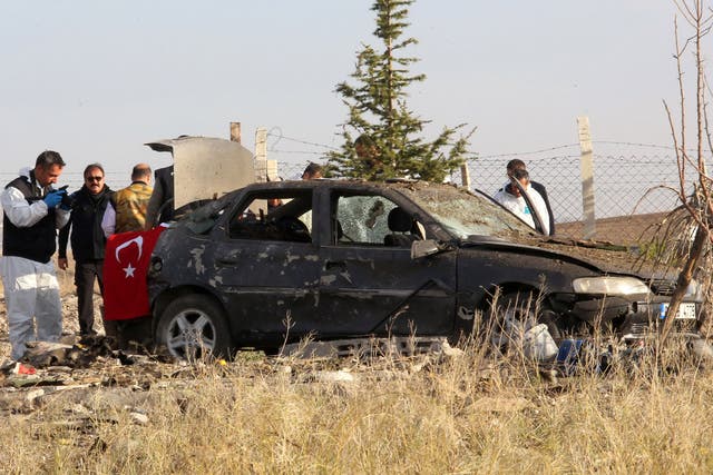 Police forensic experts examine a car after a blast detonated by two militants, in the countryside of Haymana near Ankara, Turkey, October 8, 2016.
