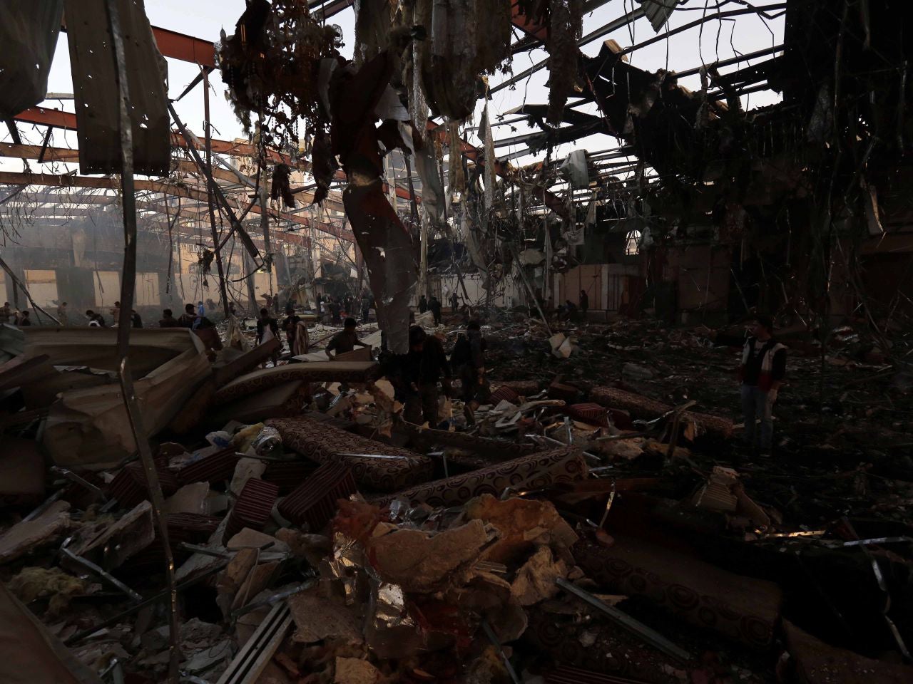 People inspect the aftermath of the suspected airs trike in Sanaa