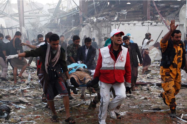 Medics and rescue workers amid the destruction at the site of reported air strikes in Sana’a on 8 October