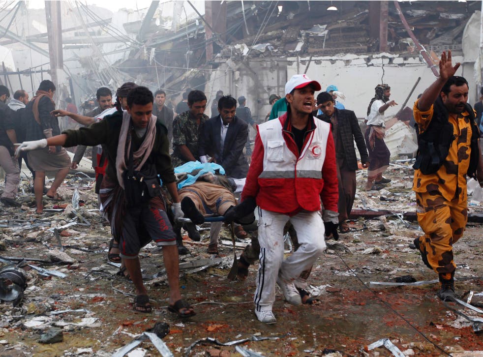 Medics and rescue workers amid the destruction at the site of reported air strikes in Sana’a on 8 October