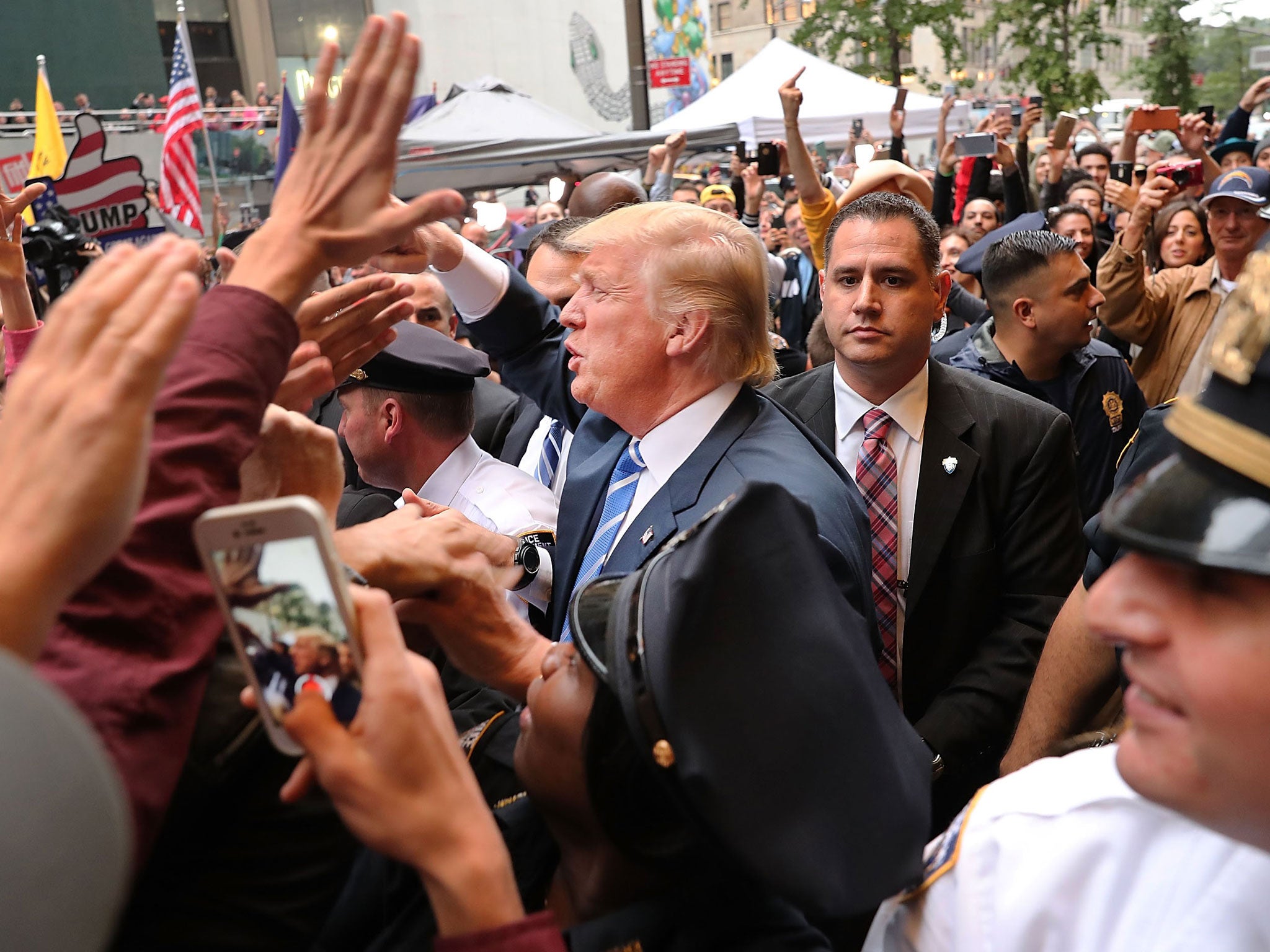 Donald Trump greets supporters outside Trump Towers but he is less lauded in Britain