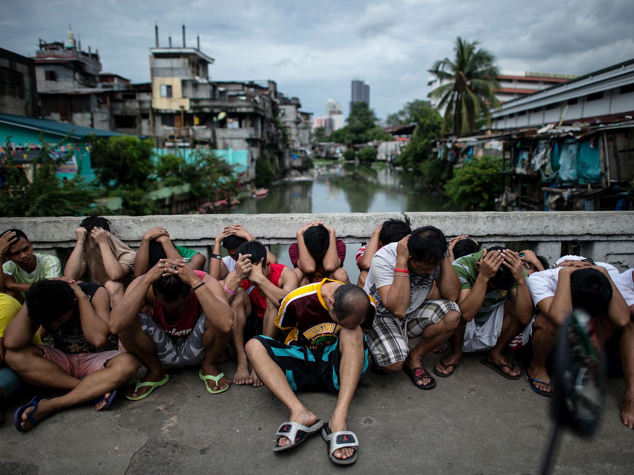 Filipino men are rounded up during a police operation as part of the continuing 'War on Drugs' campaign of Philippine President Rodrigo Duterte in Manila