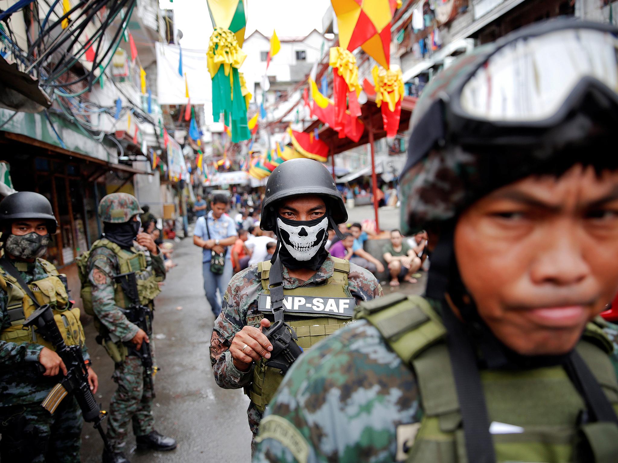 Armed security forces take a part in a drug raid, in Manila
