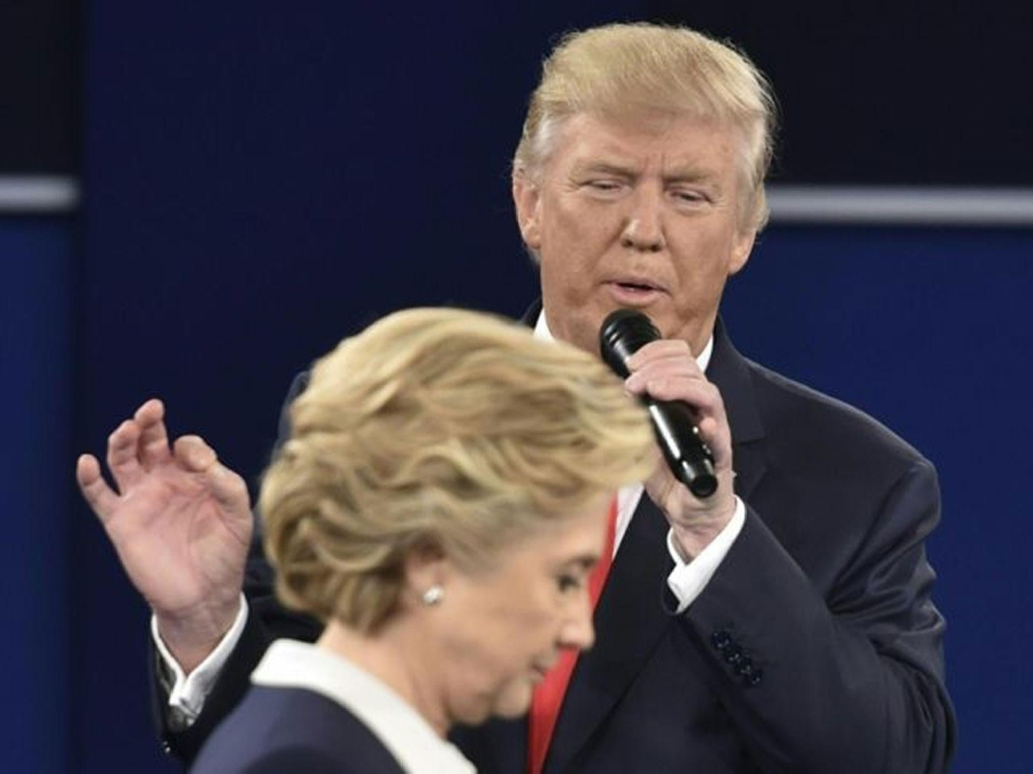 Republican presidential candidate Donald Trump speaks as Democratic presidential candidate Hillary Clinton walks past during the second presidential debate at Washington University in St. Louis, Missouri on 9 October, 2016