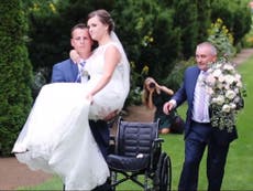 Woman seriously injured in car crash gets carried down the aisle by groom weeks later