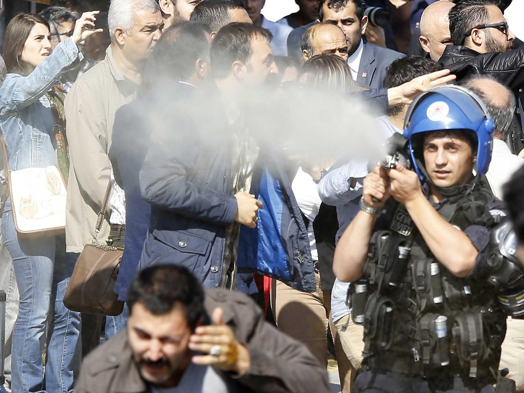 Turkish police use tear gas spray to disperse the crowd during the commemoration of the 1st anniversary of Ankara bombings of 2015