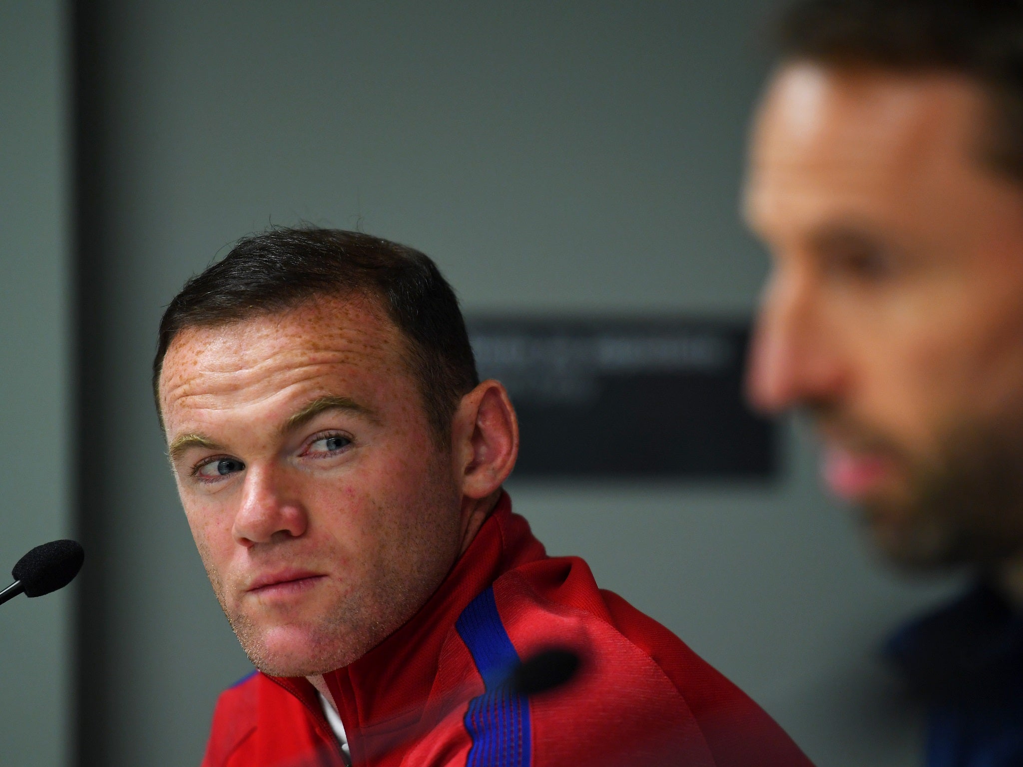 Wayne Rooney watches on as Gareth Southgate explains the decision to drop him