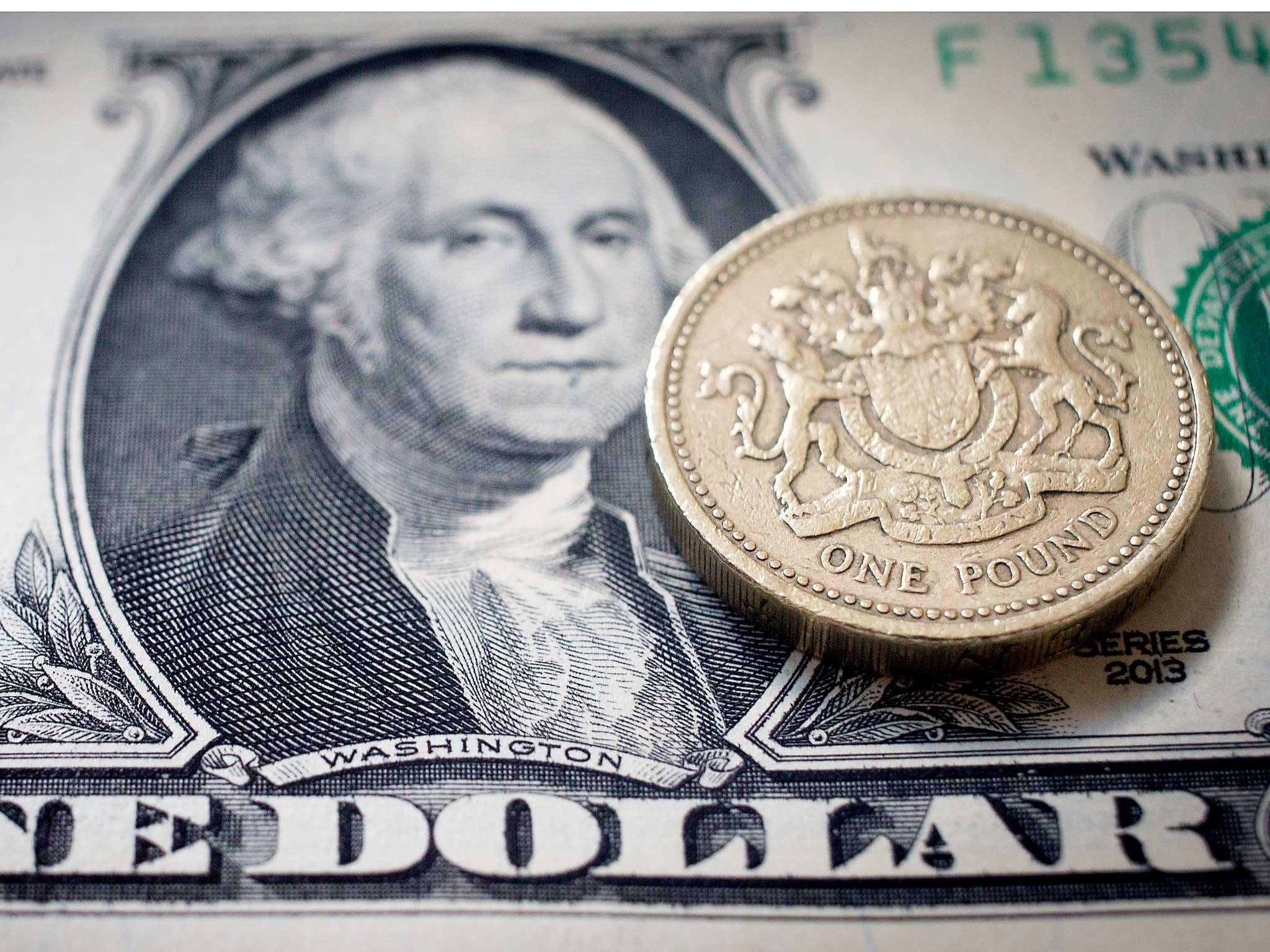 A one pound sterling coin on top of a US dollar bill