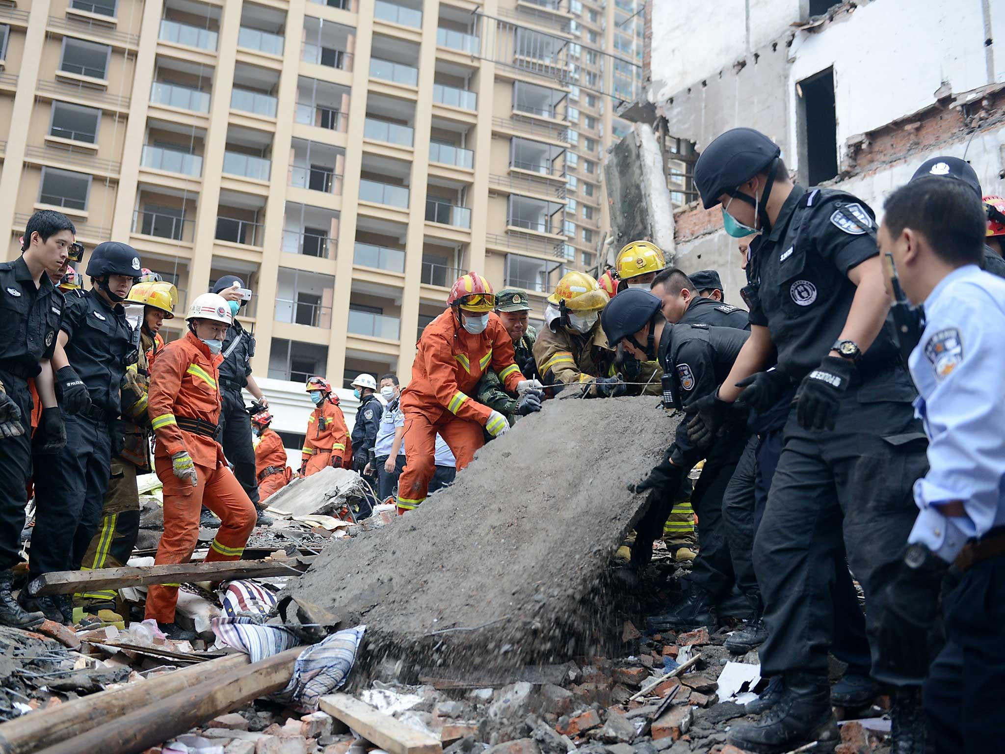 Rescue workers search the site where residential buildings collapsed in Wenzhou