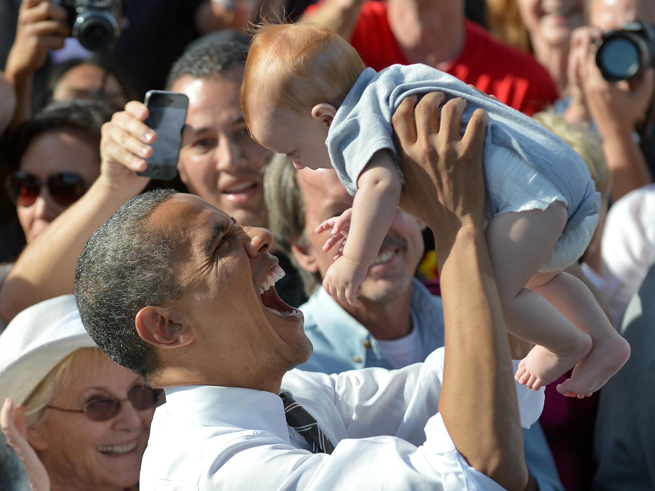 US President Barack Obama holds a baby