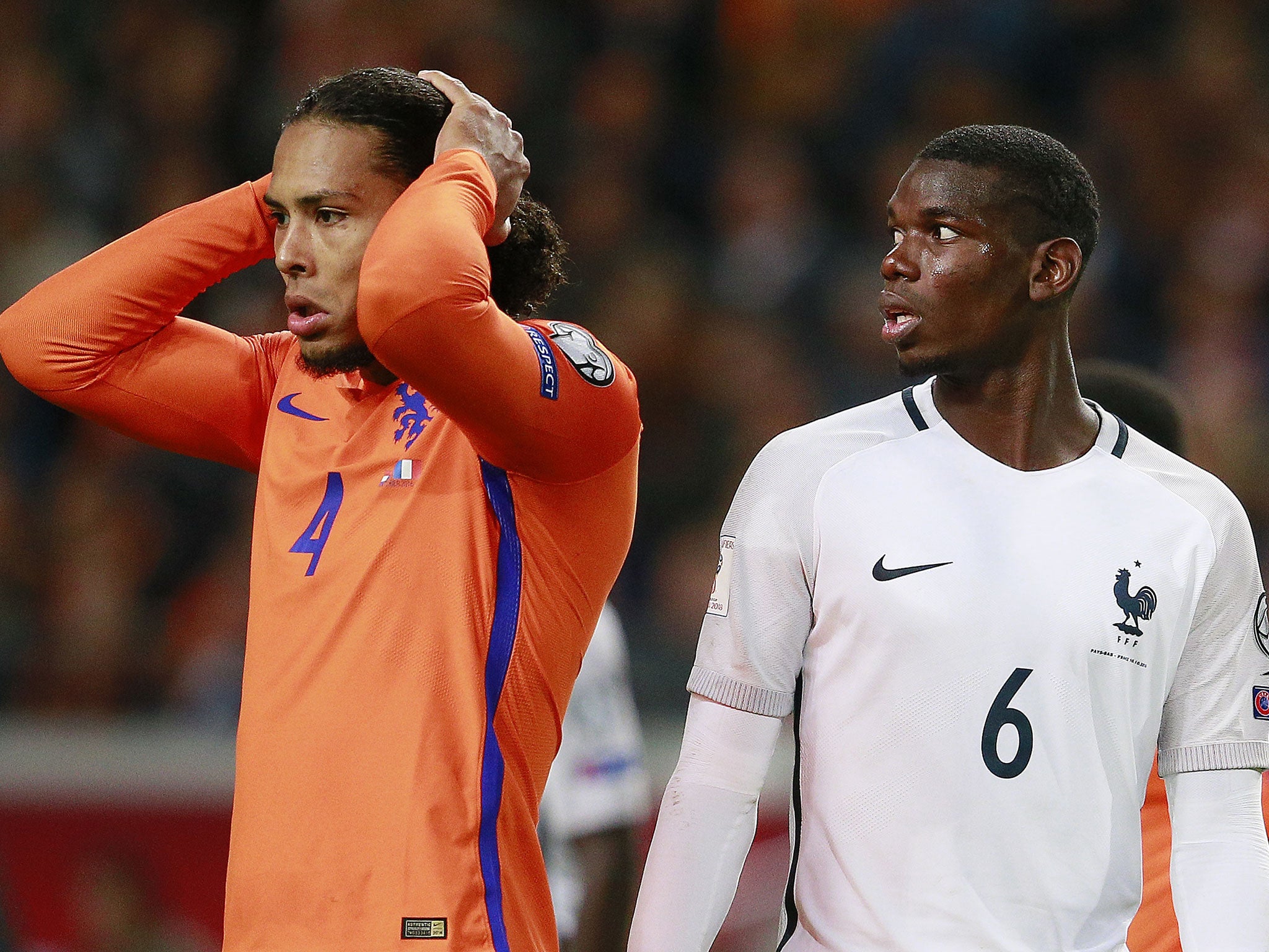 Holland's Virgil Van Dijk holds his head in his hands as France's Paul Pogba looks on in Amsterdam