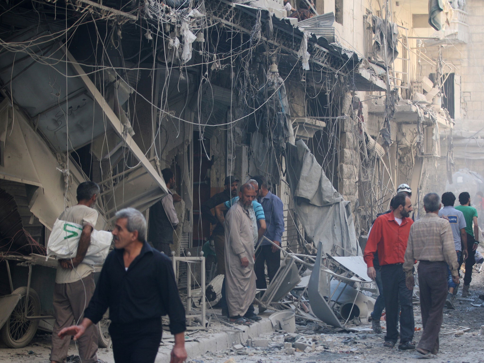 Civil defence members and men inspect a site damaged after an airstrike in the besieged rebel-held al-Qaterji neighbourhood of Aleppo, Syria, 11 October, 2016