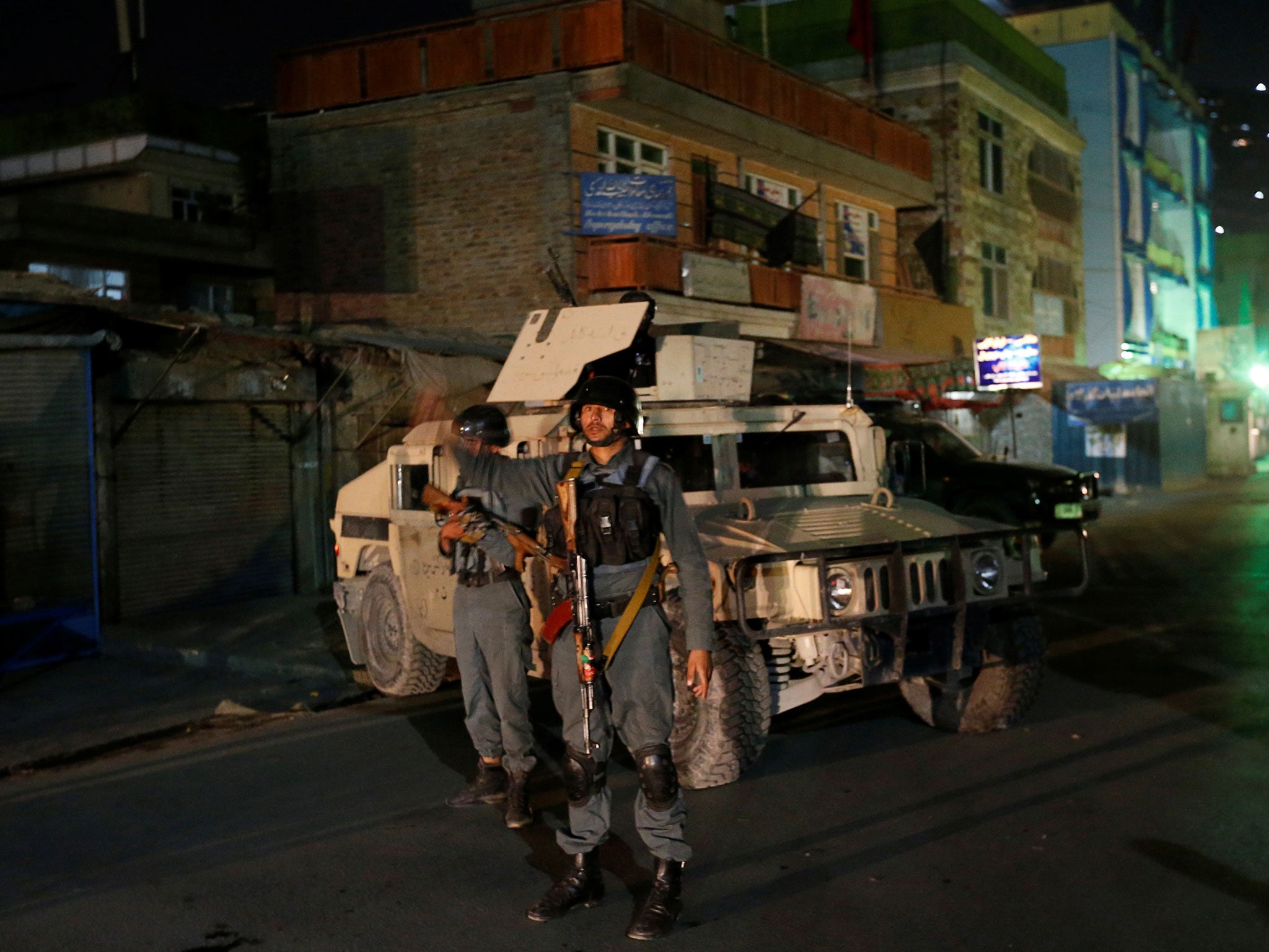Afghan policemen stand guard near the site of the attack in Kabul