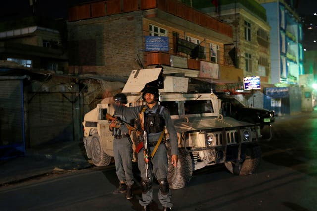 Afghan policemen stand guard near the site of the attack in Kabul