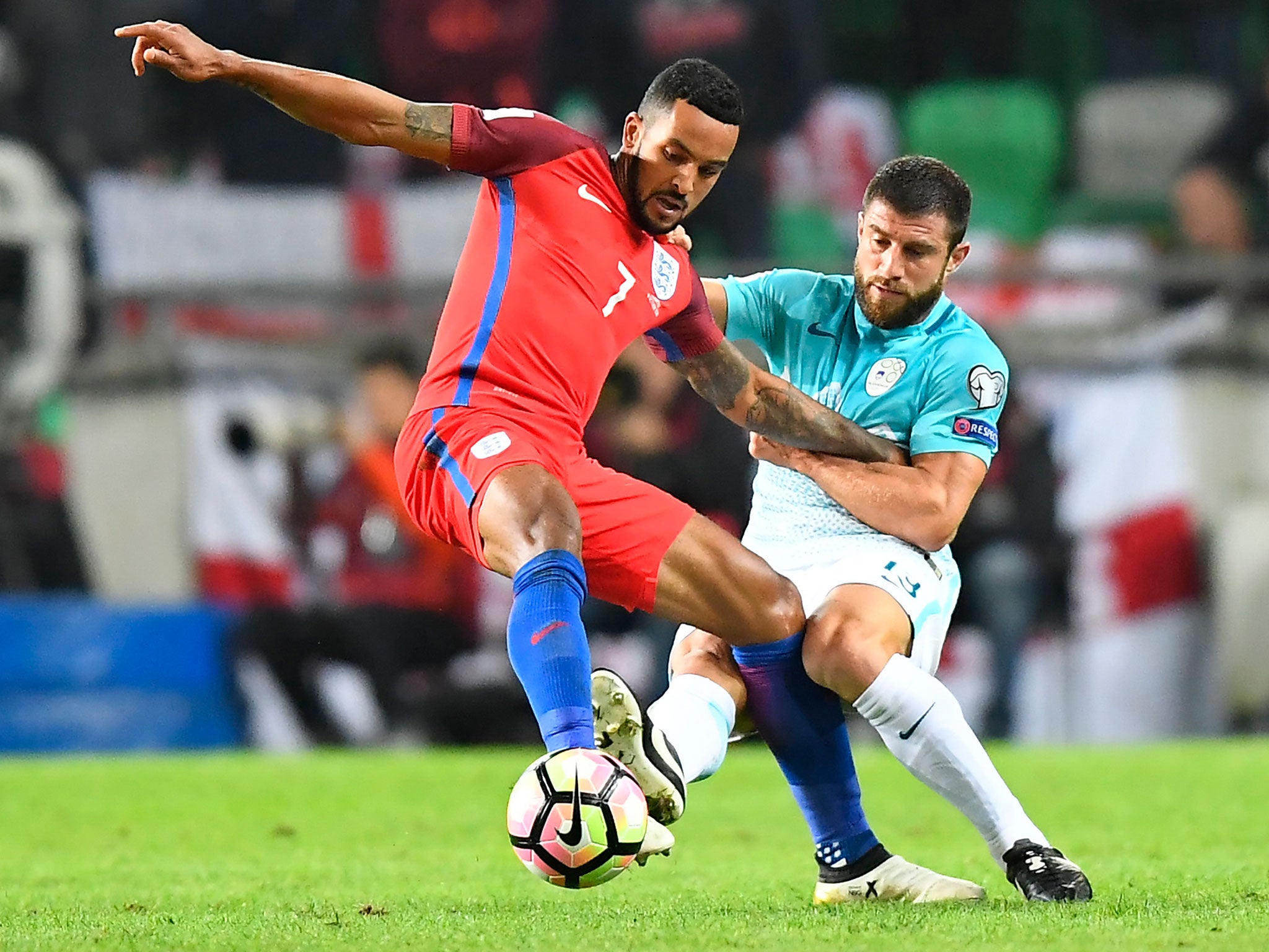 Theo Walcott battles for possession against Slovenia
