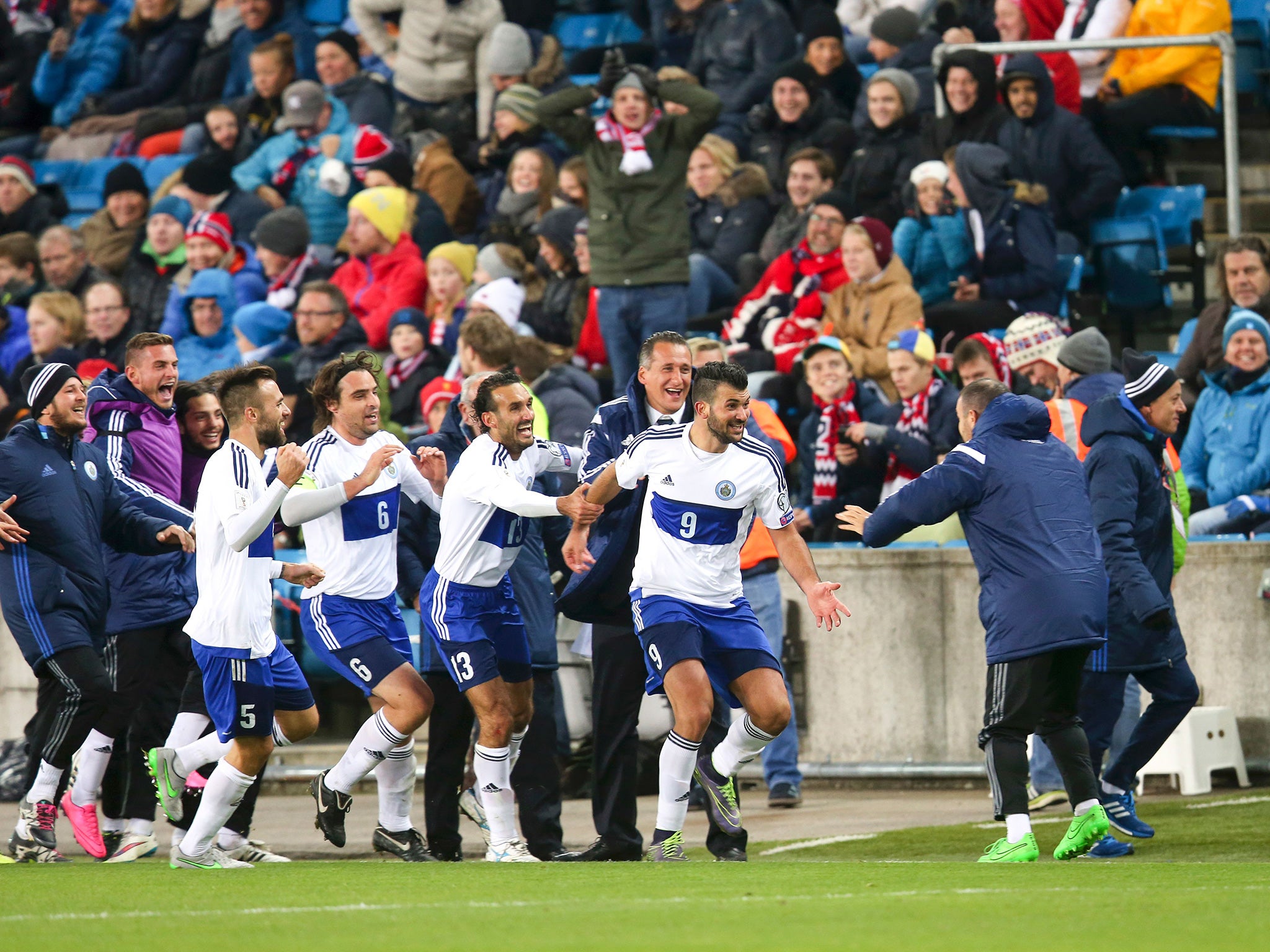 Stefanelli celebrates his strike with his team-mates and San Marino's staff