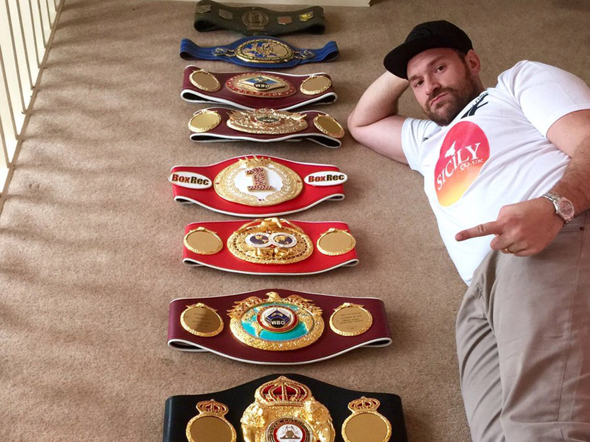 Tyson Fury shows off his world titles ahead of his expected decision to vacate the belts