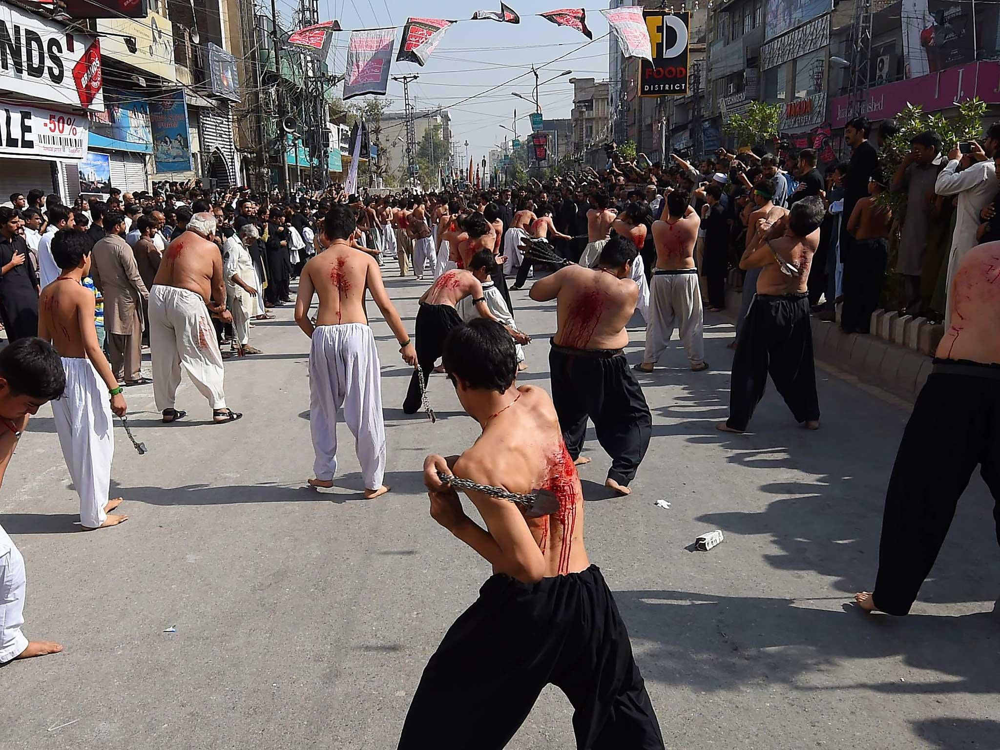Pakistani Shiite Muslims flagellate themselves during the Ashura procession in Peshawar. The Islamic month of Muharram marks the seven-century martyrdom of Prophet Mohammad's grandson Imam Hussein who was killed in battle in Karbala in Iraq in 680 AD