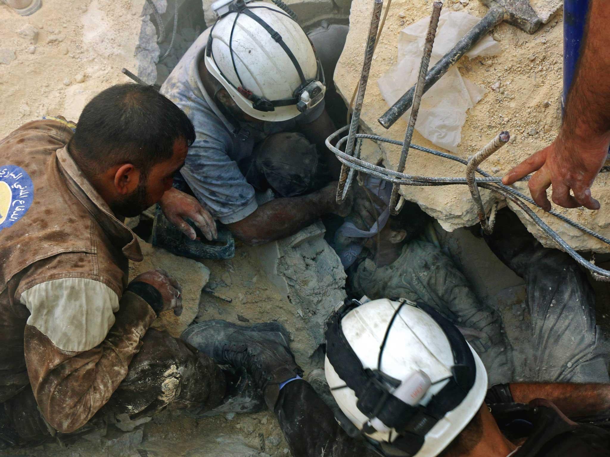 Jameel Mustafa Habboush, receives oxygen from civil defence volunteers, known as the white helmets, as they rescue him from under the rubble of a building following Russian air strikes on the rebel-held Fardous neighbourhood of the northern embattled Syrian city of Aleppo