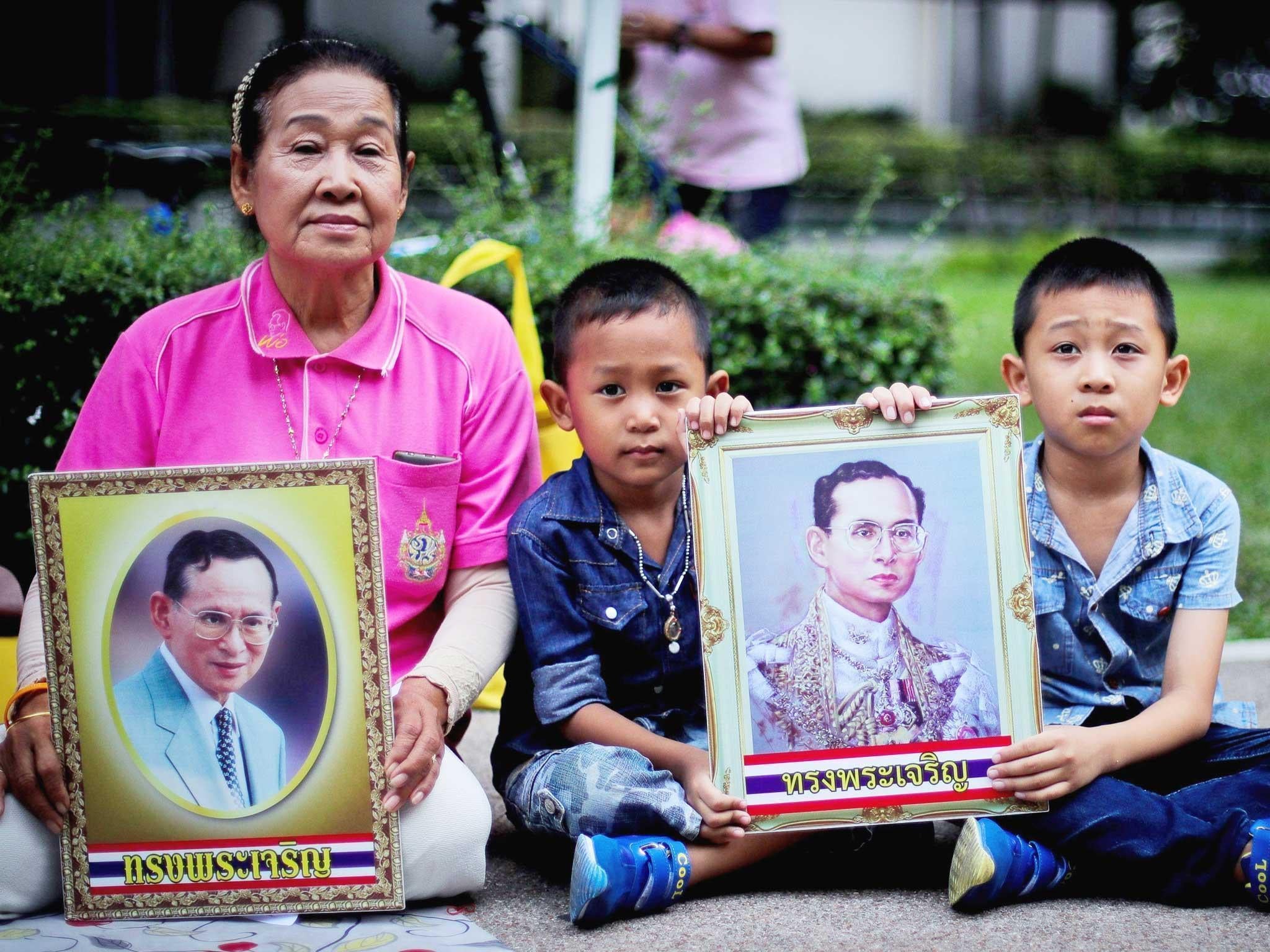 Thai well-wishers pray with portraits of Thai King Bhumibol Adulyadej, wishing for the King's recovery, outside the Siriraj Hospital in Bangkok, Thailand