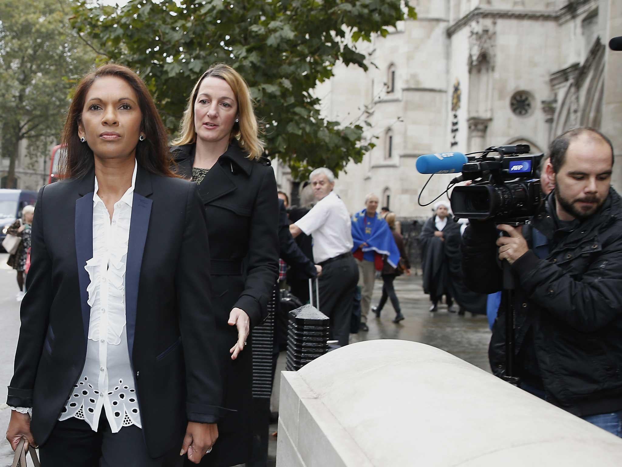Gina Miller, left, walks past the High Court prior to the start of her landmark lawsuit, in London.