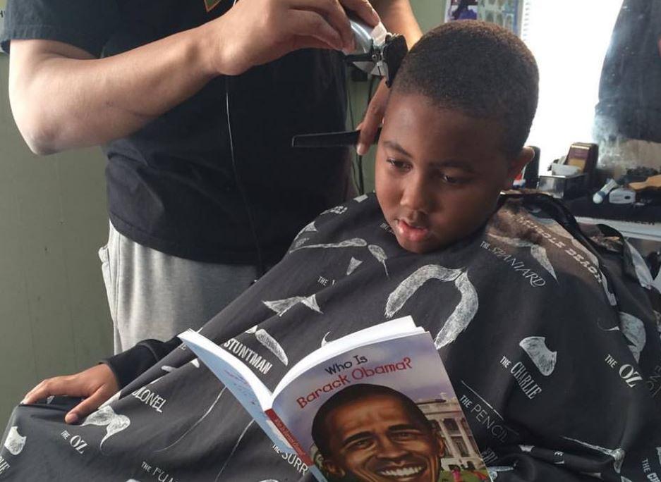 A child at Fuller Cut reading a book about Barack Obama.