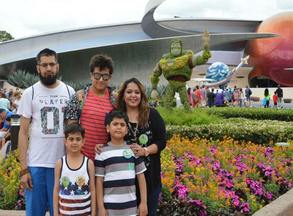 Mr Usmani, his wife and three sons standing in front of a sculpture of Buzz Lightyear from 'Toy Story'