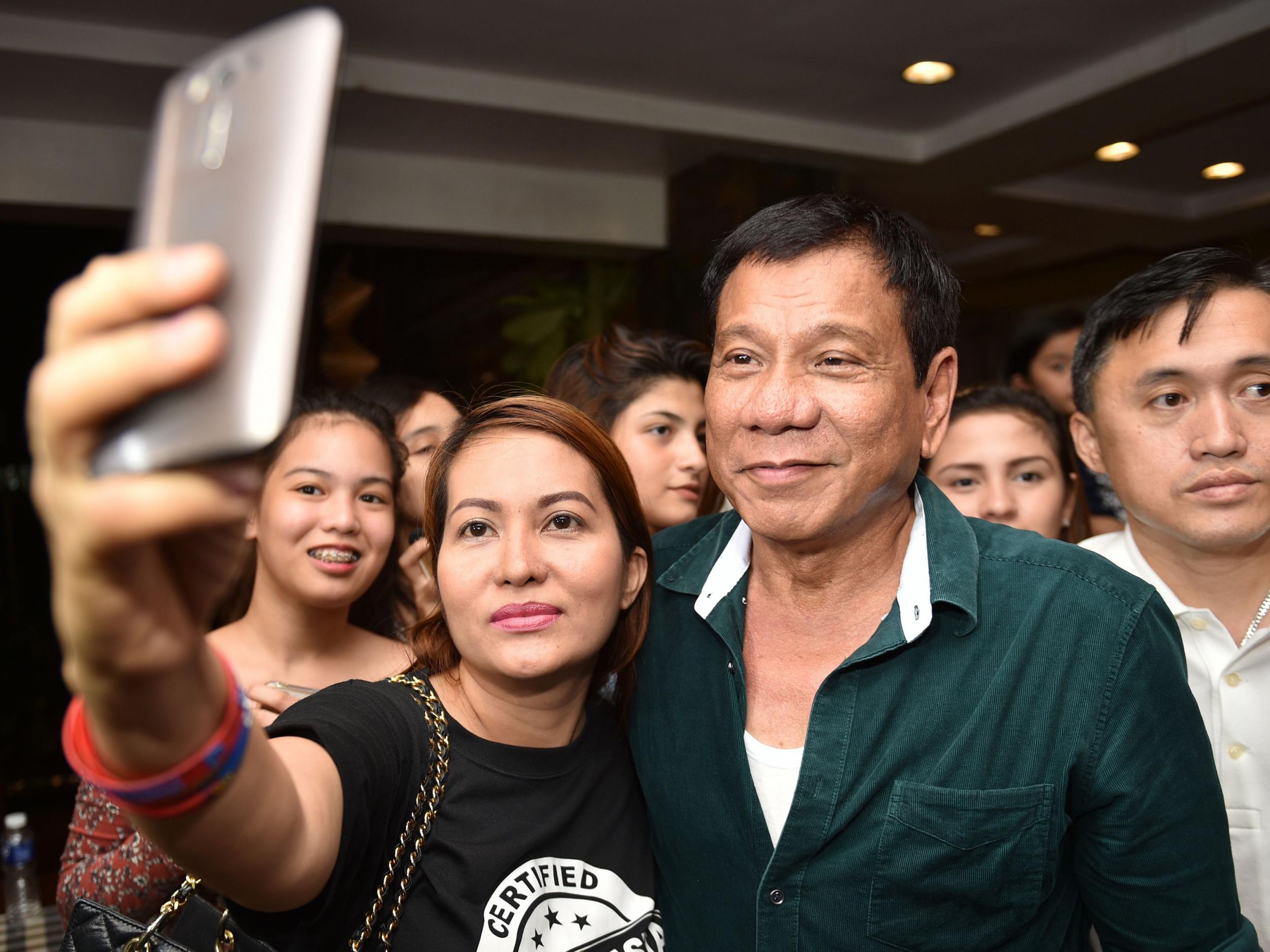 Philippine President-elect Rodrigo Duterte poses for pictures with supporters